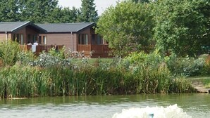A lakeside cabin with a deck and a view of the water.