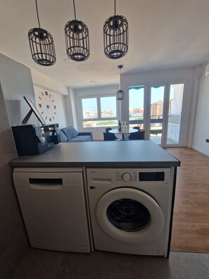 Cozy living space with a central kitchen, dining area, and seating space offering a city view.