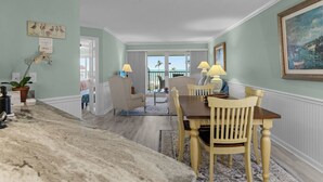 Un comedor con encimera de mármol, sillas de madera y vistas al exterior.