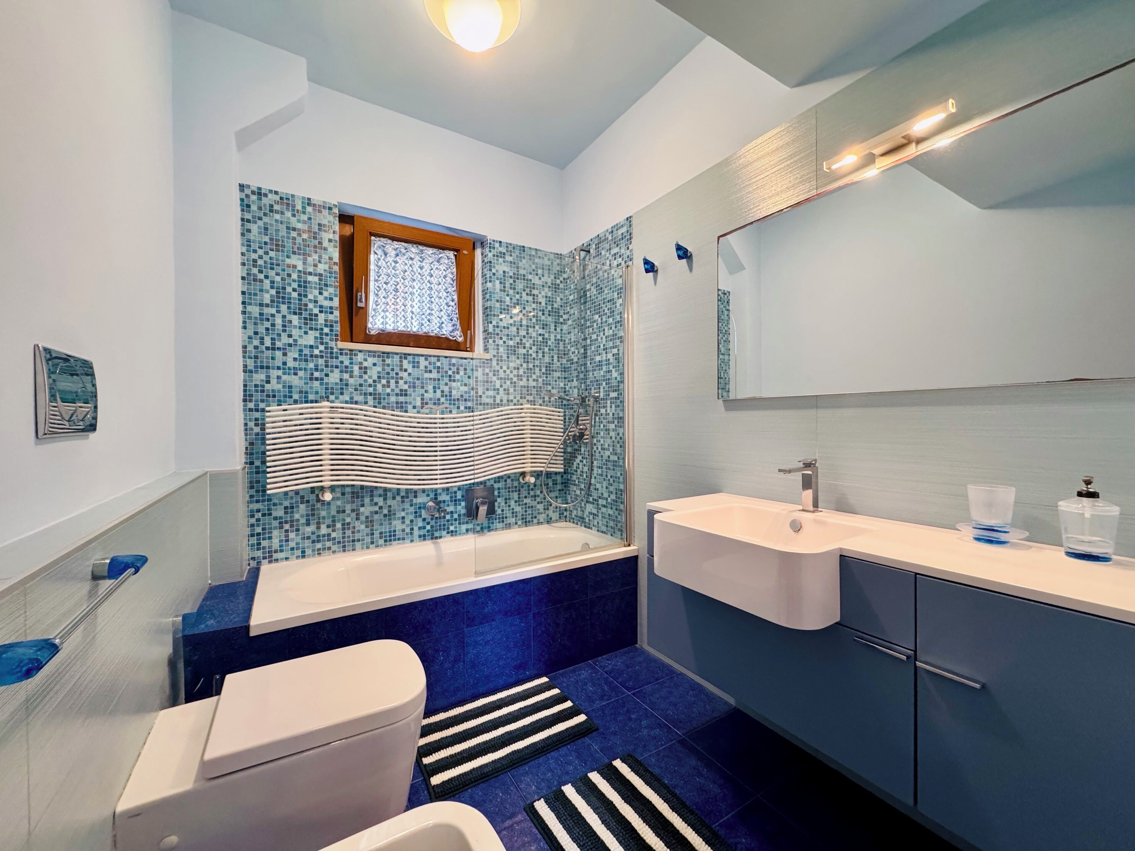 A modern bathroom with a bathtub, toilet, and sink.