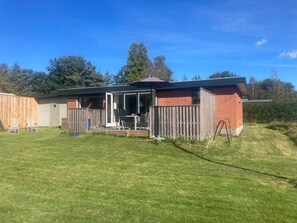 A single-story building with a patio area, a fenced backyard, and a wooden deck. - 5 Person Holiday Home in Sydals (Sydals)