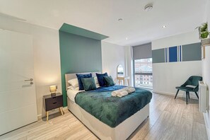 Een moderne slaapkamer met een bed, nachtkastje en uitzicht op de stad.