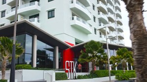 A modern hotel with a prominent 'STK' sign, multiple balconies, and a well-maintained outdoor area with palm trees. - Deluxe Ocean View Studio with Free Parking & Pool (San Juan)