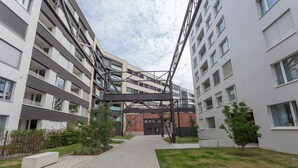 Un immeuble d’appartements moderne doté d’une cour intérieure, de nombreux balcons et d’une façade en briques.