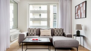 Un salon moderne avec un canapé gris, une table basse et une lampe sur une table d’appoint.