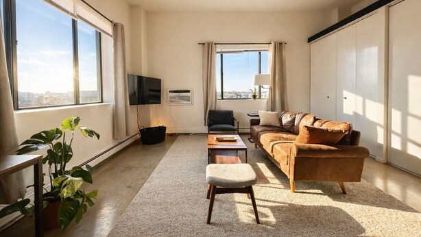 Una sala de estar moderna con un sofá, un sillón y un televisor.