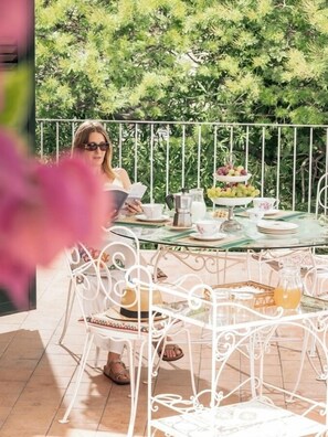 A balcony with a table set for tea, surrounded by white metal chairs. - Charming 3-bedroom country house with Jacuzzi and tank pool (Zafferana Etnea)
