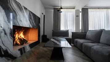 Una sala de estar moderna con una chimenea de mármol, un sofá y una mesa de centro.
