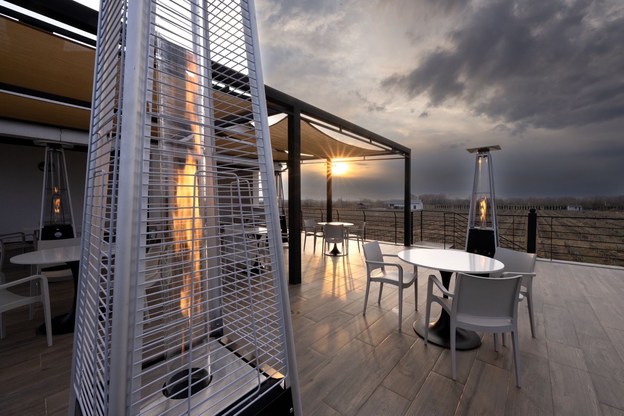 Un patio exterior con mesa y sillas, una parrilla y vistas al paisaje.