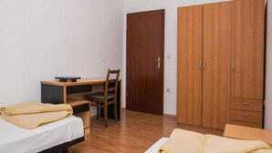 Ein Schlafzimmer mit Bett, Schreibtisch, Stuhl und Kleiderschrank.