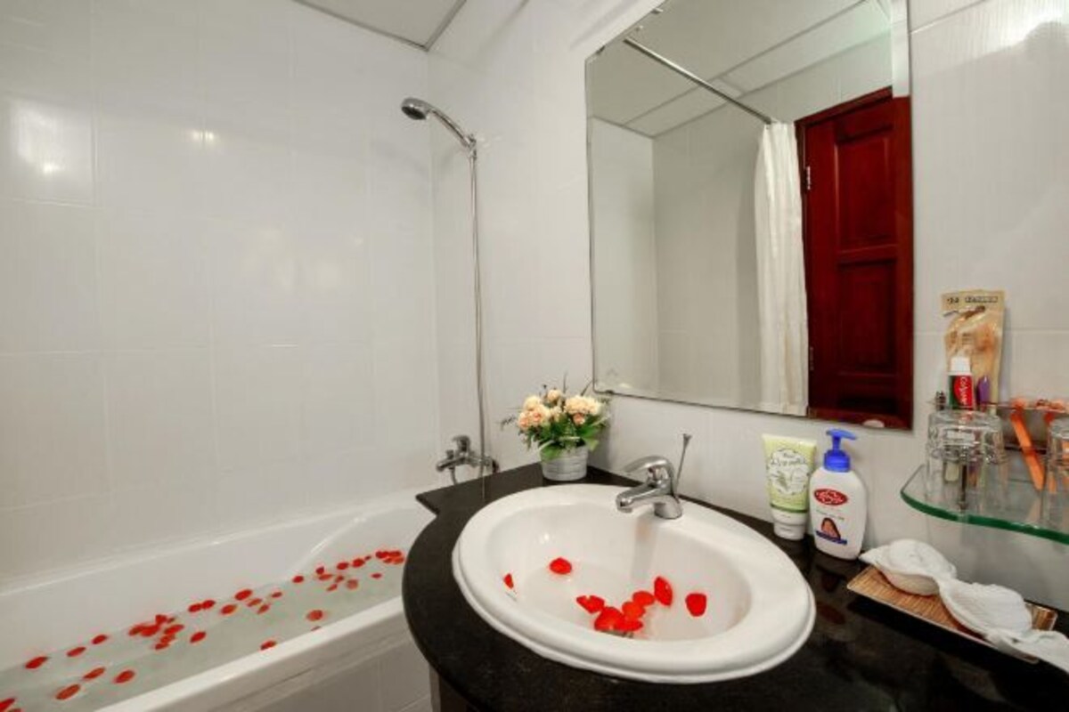 A bathroom with a bathtub, a sink, and a shower.