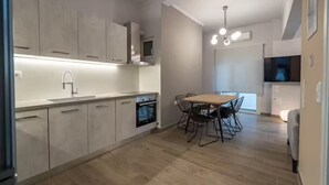 Una cocina moderna con comedor, electrodomésticos integrados y televisión.