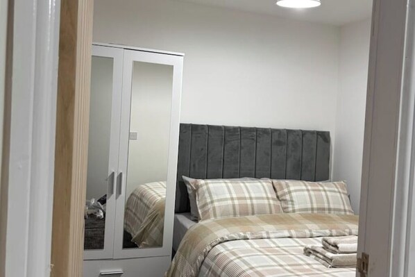 Ein Schlafzimmer mit einem Bett, einem Kleiderschrank und einem Spiegel.