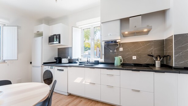A modern kitchen with a built-in dishwasher, a microwave, and a coffee maker. - Modern Retreat in Castro Marim by LovelyStay (Castro Marim)