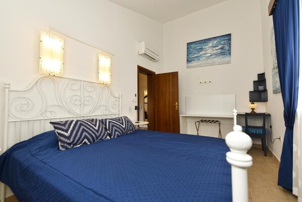 Une chambre à coucher avec un lit, un bureau et une chaise.