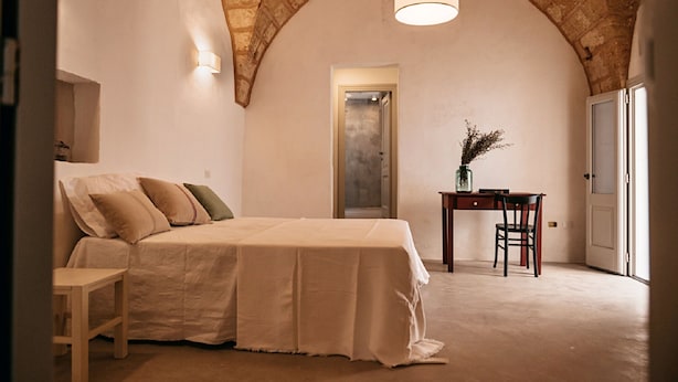 A bedroom with a bed, a desk, and a chair. - Palazzo Pati - Suite Deluxe (Tiggiano)