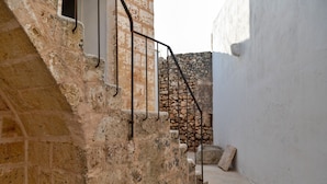 A stone staircase with metal railings leading to a stone wall. - Palazzo Pati - Suite Deluxe (Tiggiano)