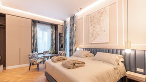 A modern bedroom with a large bed, a desk, and a chair. - Villa Madre Suites e Private Spa (Grottaferrata)