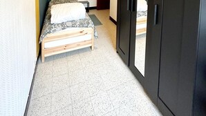 A bedroom with a bed, a wardrobe, a door, and a ceiling light. - Apartment 700 Meters From Baldus Beach (Koksijde)