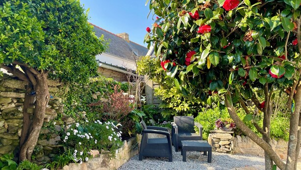 A garden patio with stone walls, a gravel path, and outdoor furniture. - Ty Camelia-Draps included-4p-Wifi-Enclosed garden (QUIBERON)