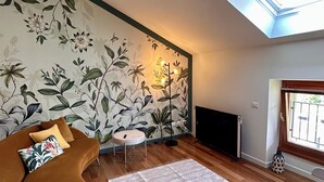 A modern living room with a curved sofa, a small round table, and a patterned wall. - Historia Suite Bellagio (Bellagio)