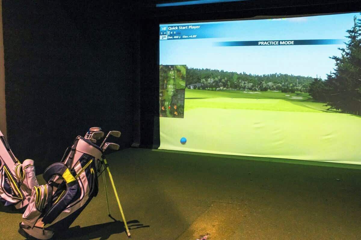 Um carrinho de golfe e uma tela exibindo um campo de golfe em modo de treino.