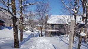 A snowy residential area with houses, trees, and a clear sky. - True Ski In/Out  2 bedroom condo (Jay)