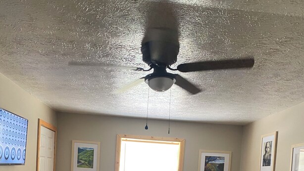 A living room with a sectional sofa, a ceiling fan, a window with blinds, and framed pictures on the wall. - Welcome to Gods country lodging located in the heart of Hatfield and mcoy trails (Delbarton)