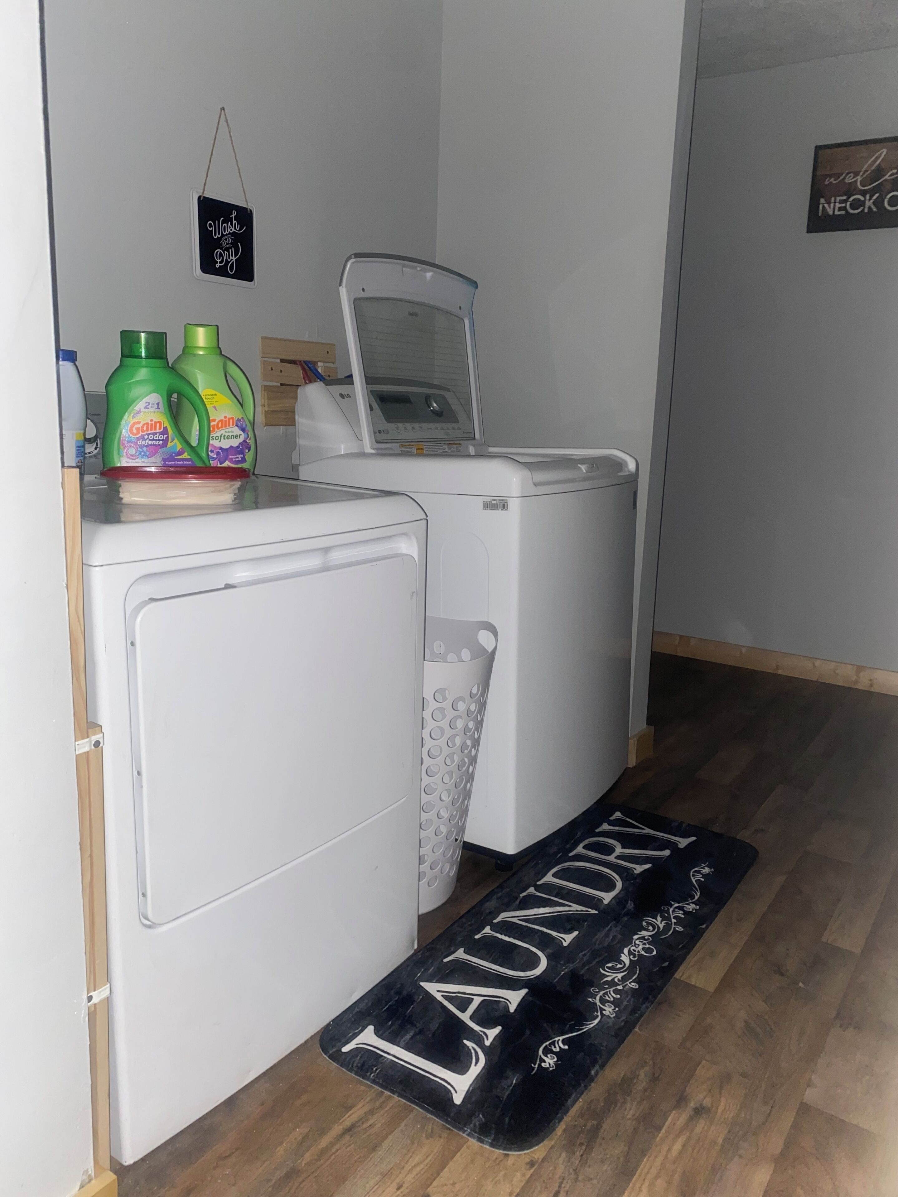 A laundry area with a washing machine, dryer, and a mat labeled 'LAUNDRY.'