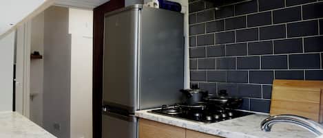 Enjoy cooking in this well-equipped kitchen with a gas stove, refrigerator, and ample counter space.