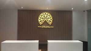 Ein Empfangsbereich mit dem Logo von 'Hotel Spring Stays' an der Wand.