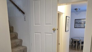 A staircase with carpeted steps leading to a white door. - Charming cottage, 3Qn w/ WiFi, Parking, AC walkable to Clftn Nrthsd near dwntwn (Cincinnati)