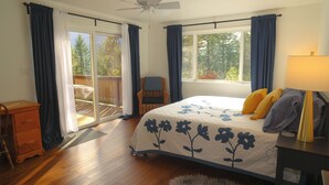 A bedroom with a bed, a chair, a desk, and a window with curtains. - Sauna, River Views, Book Nook, 4BR Homestead Retreat (Stevenson)