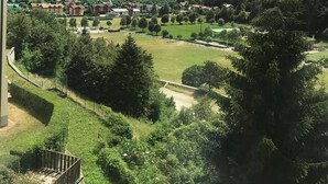 Een uitzicht op een bergachtig landschap met een meer, een dorp en een gebouw met een balkon.