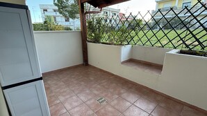 A balcony with tiled flooring, a metal fence, and a view of neighboring buildings. - Welcoming and well-kept, it is the perfect base for discovering the wonders of Salento. (Lizzanello)