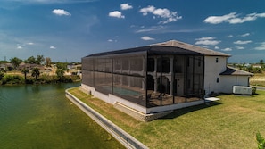A house with a large screened porch overlooking a body of water.