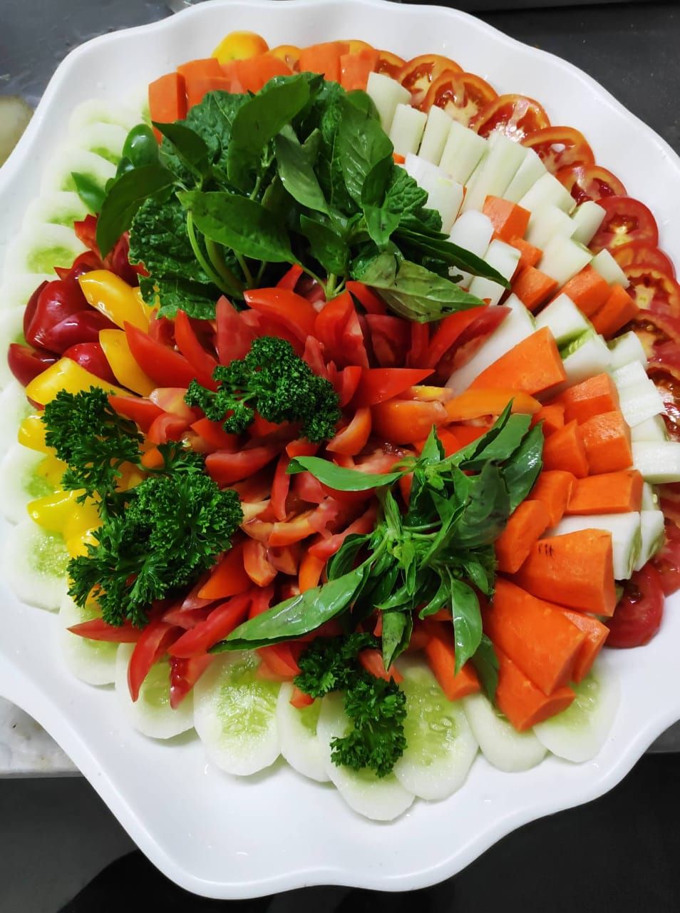 Una bandeja con una variedad de vegetales y hierbas cortadas.