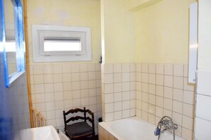 A bathroom with a bathtub, a window, and a chair. - Sunny Apartment in Koksijde With Coastal Views (Koksijde)