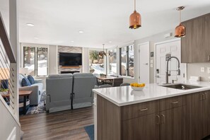 Relax in a spacious living area with a central island, sofa, and chairs, perfect for socializing or unwinding.
