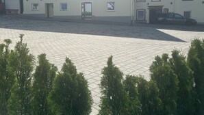 A building with a traditional half-timbered facade, a paved courtyard, and a parked car. - Hotel 7 Winde (Spaichingen)