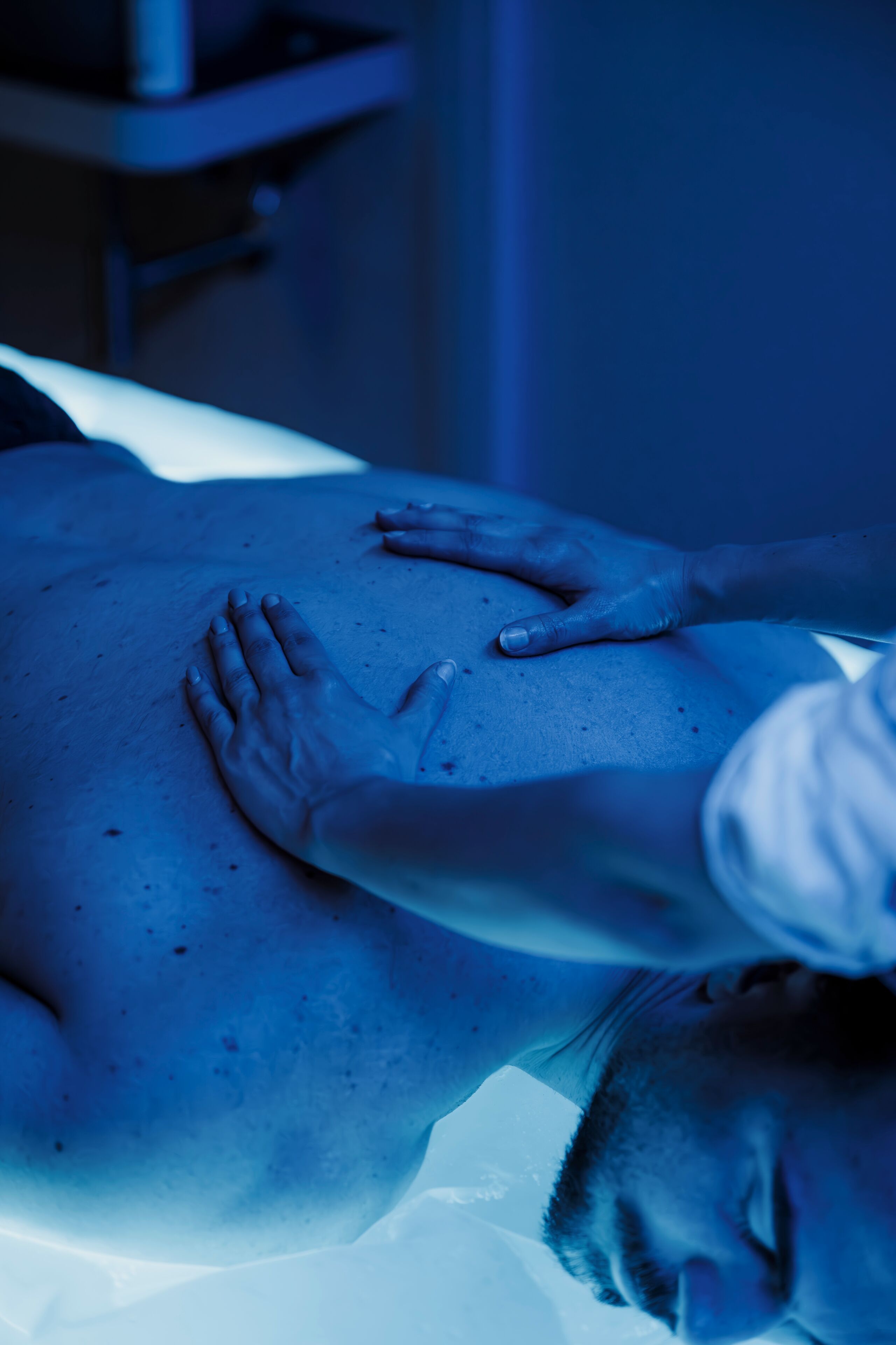 A person receiving a massage on a massage table in a clinical setting.
