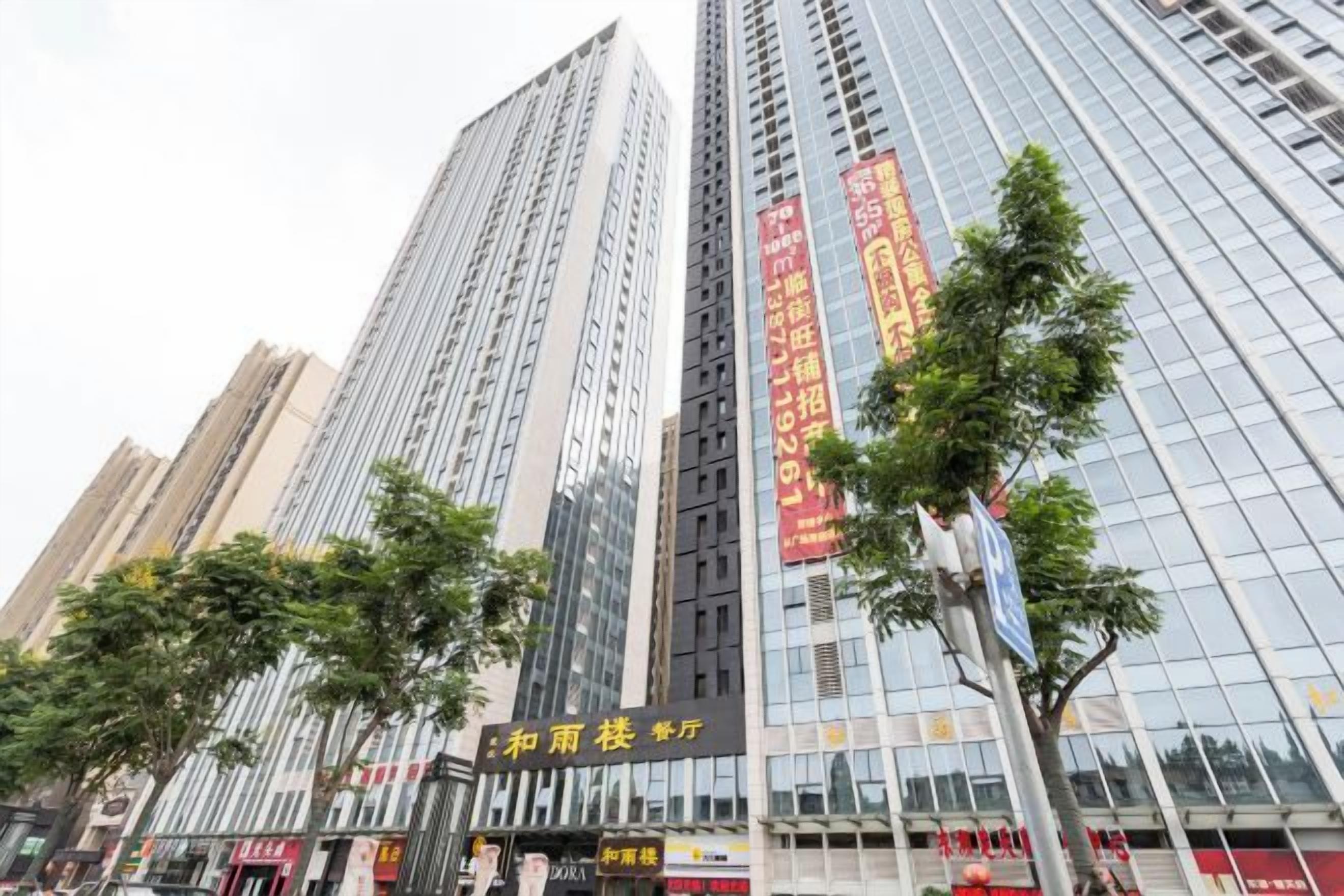 A high-rise building with multiple floors, large windows, and a sign with Chinese characters.