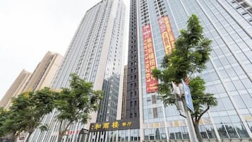 A high-rise building with multiple floors, large windows, and a sign with Chinese characters.