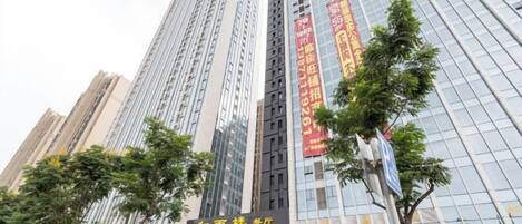 A high-rise building with multiple floors, large windows, and a sign with Chinese characters.