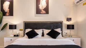 A hotel room with a large bed, two bedside tables with lamps, and artwork on the walls.