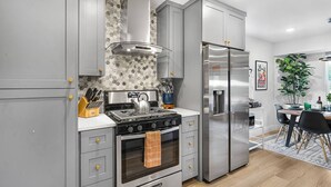 A modern kitchen with grey cabinetry, a stainless steel range, and a built-in oven.