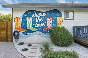 A building with a mural featuring boots and the text 'share the love.'