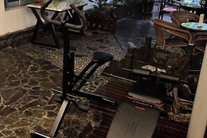 Une salle de sport équipée de matériel d’exercice, notamment un tapis de course et des appareils de musculation.