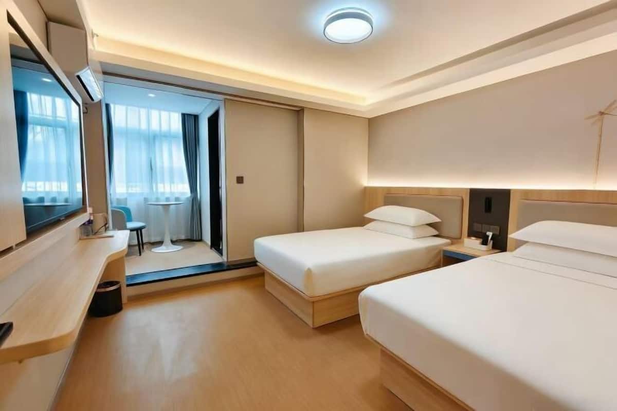 Een hotelkamer met een bed, nachtkastje en een televisie.