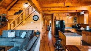 L’intérieur d’une cabane en bois comprend un espace de vie, une cuisine et un escalier.